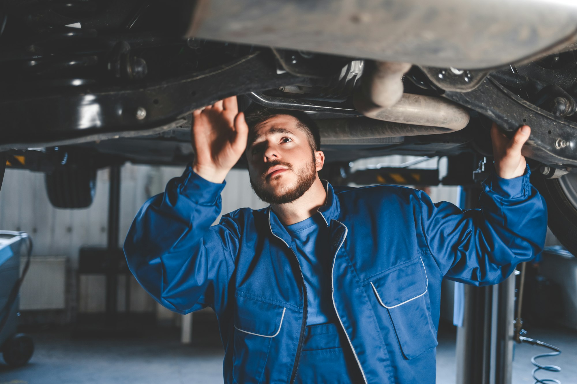 Auto mechanic inspects car suspension. Diagnostics of the condition of the car