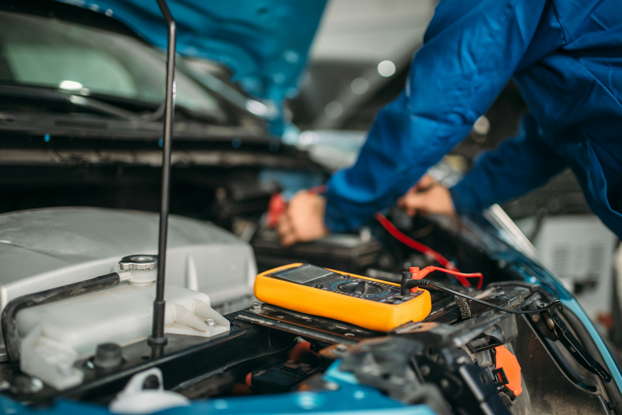 Car electrician checks the battery level