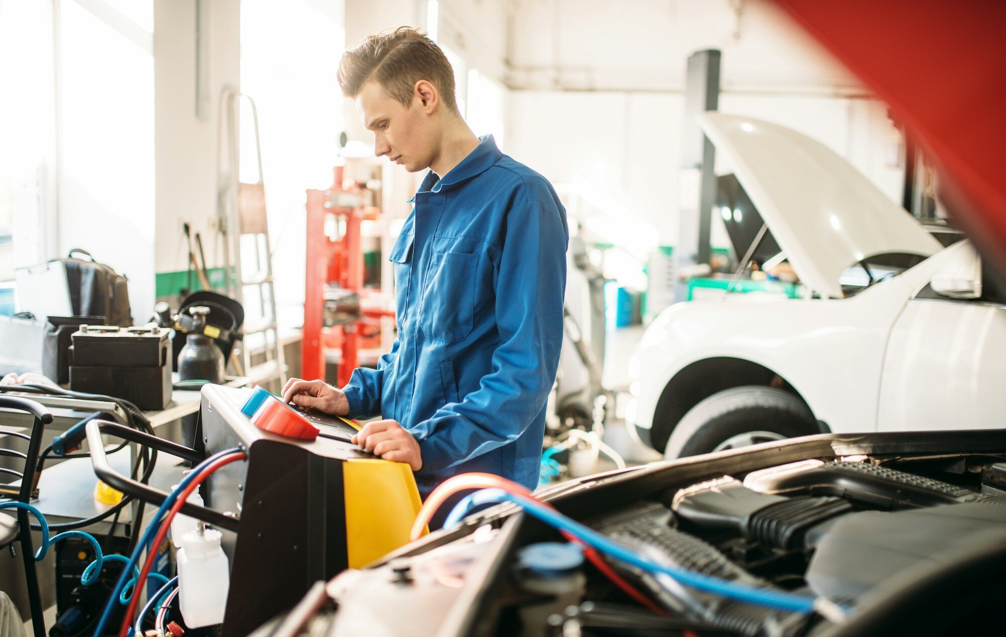 Mechanic checks air conditioning system in car